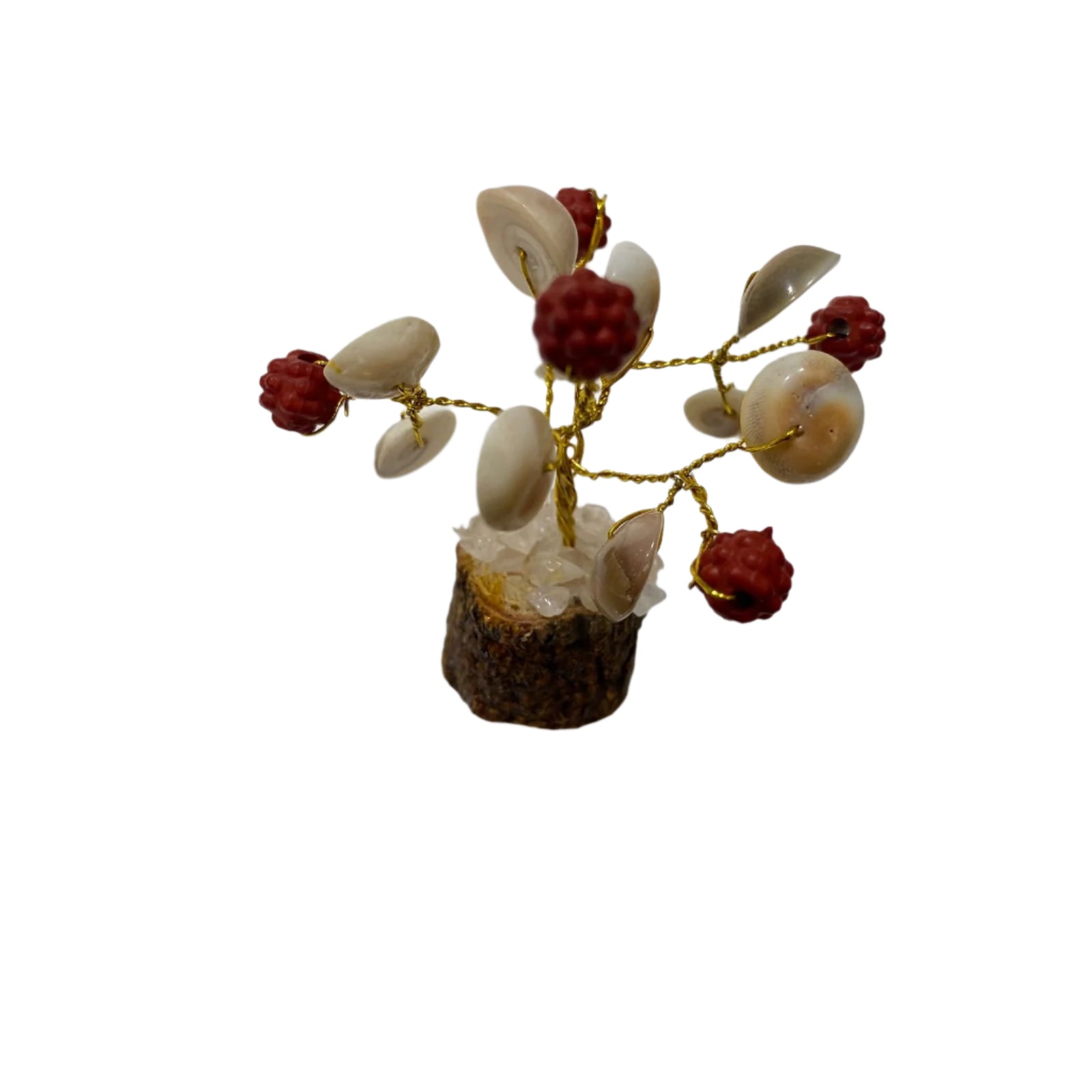 Decorative item resembling a small tree with shells and red berries on a white surface.