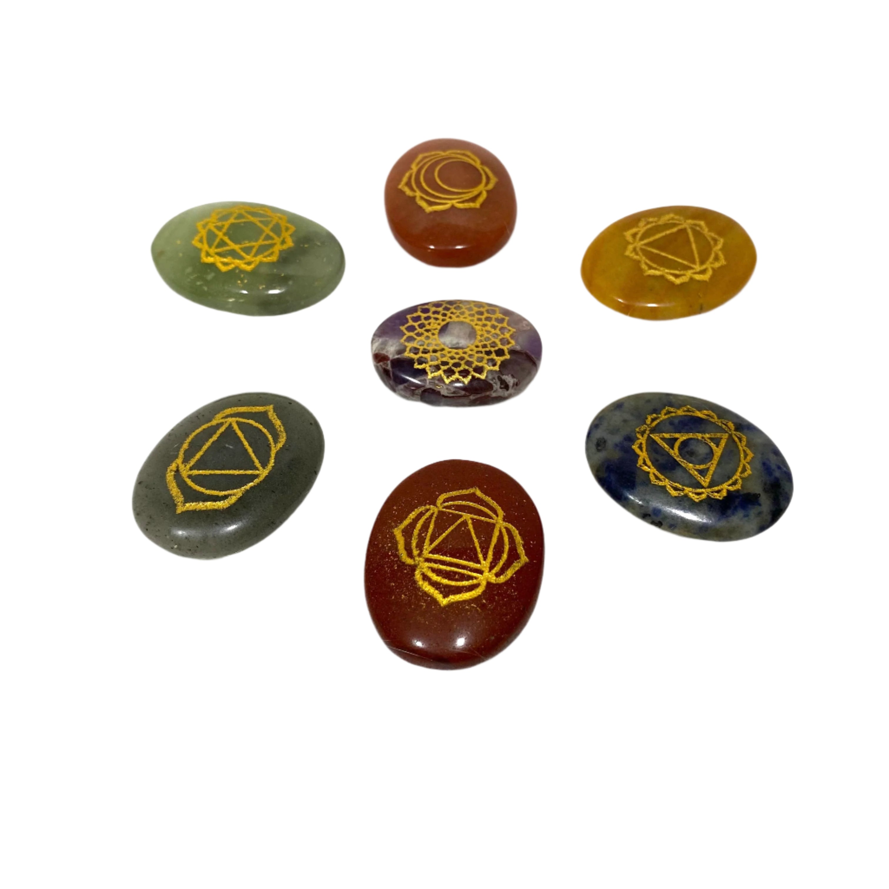 Set of stones with gold symbols on a textured white surface