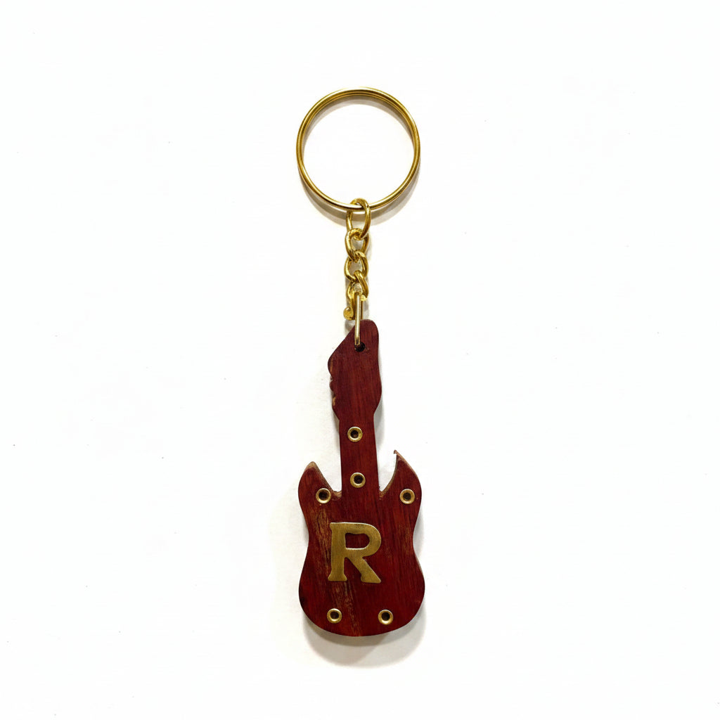 Guitar-shaped keychain with letter 'R' on a textured white background