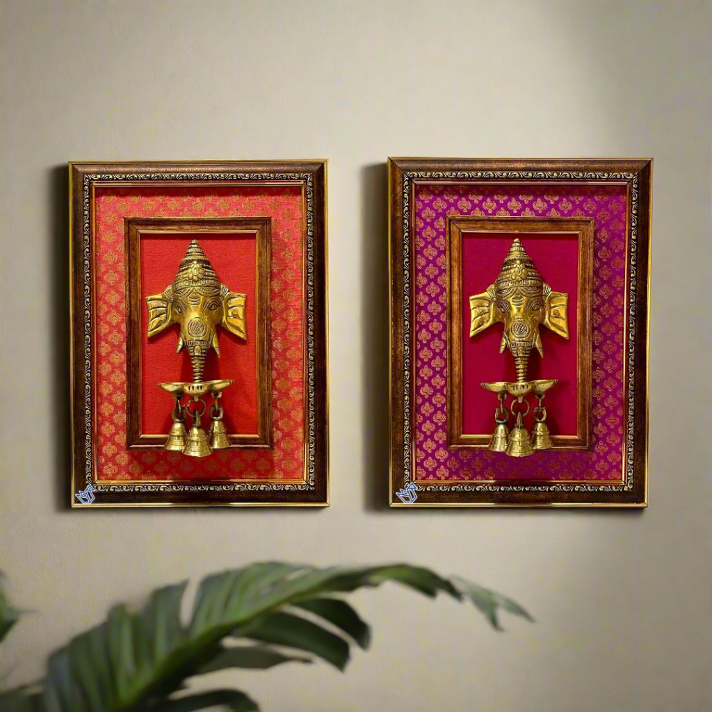 Two gold Ganesh wall art pieces in decorative frames on a white background