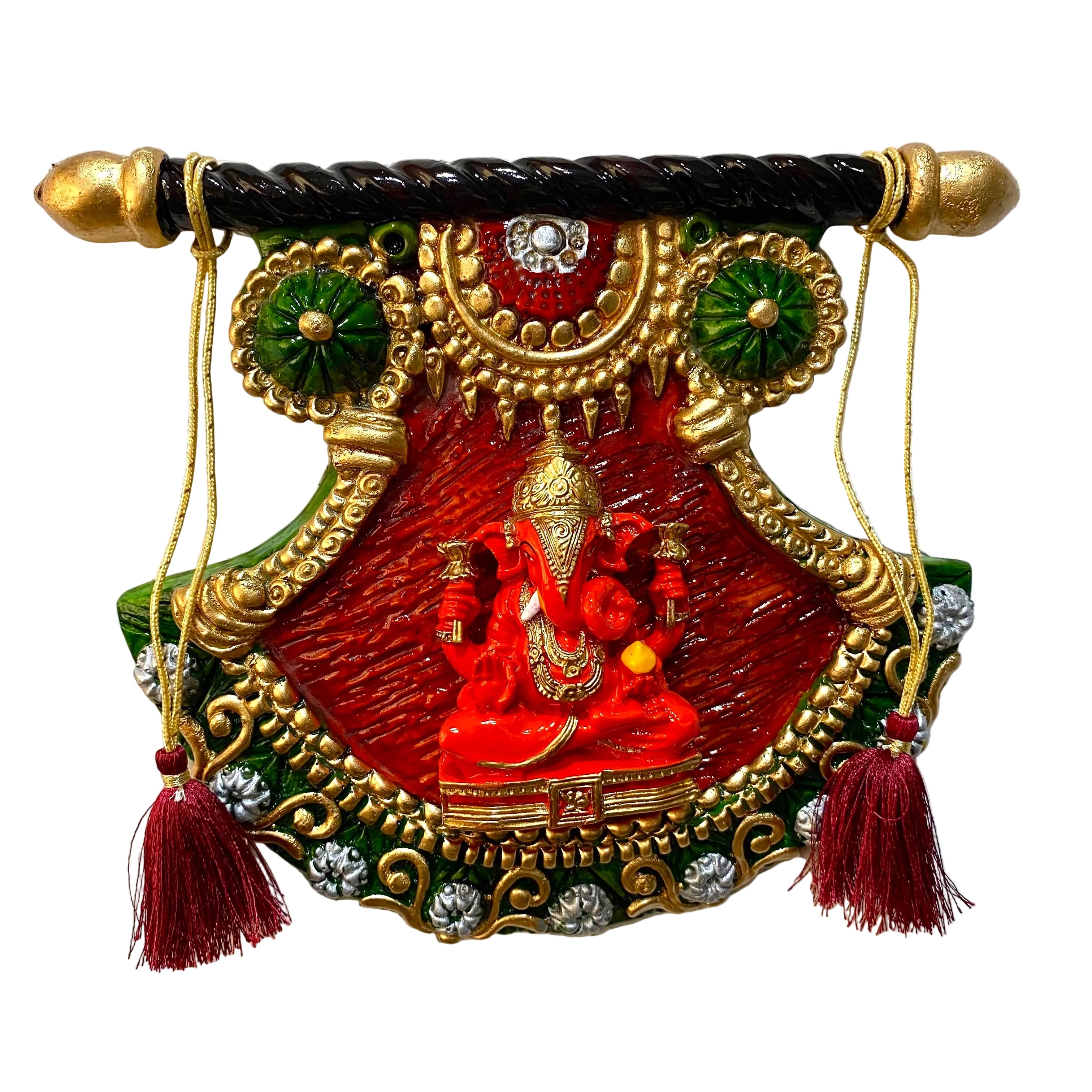 A decorative hanging wall plaque featuring a red and gold Lord Ganesha design with green accents, hanging from a black and gold finial rod against a textured white wall.