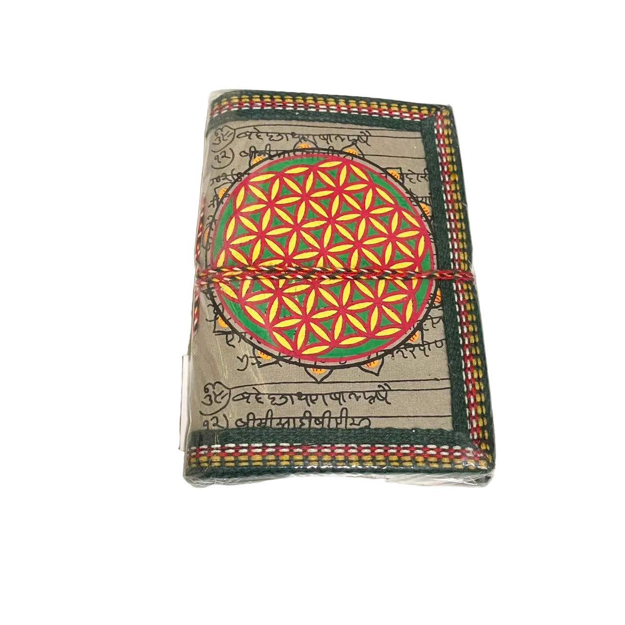 A small wrapped notebook or journal with a colorful geometric flower design on the cover, photographed on a white tabletop.