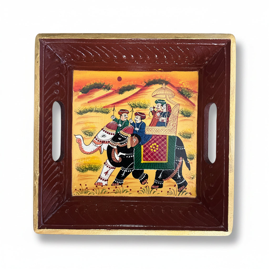 A hand-painted tray with a traditional Indian scene featuring figures on an elephant and a decorative border.