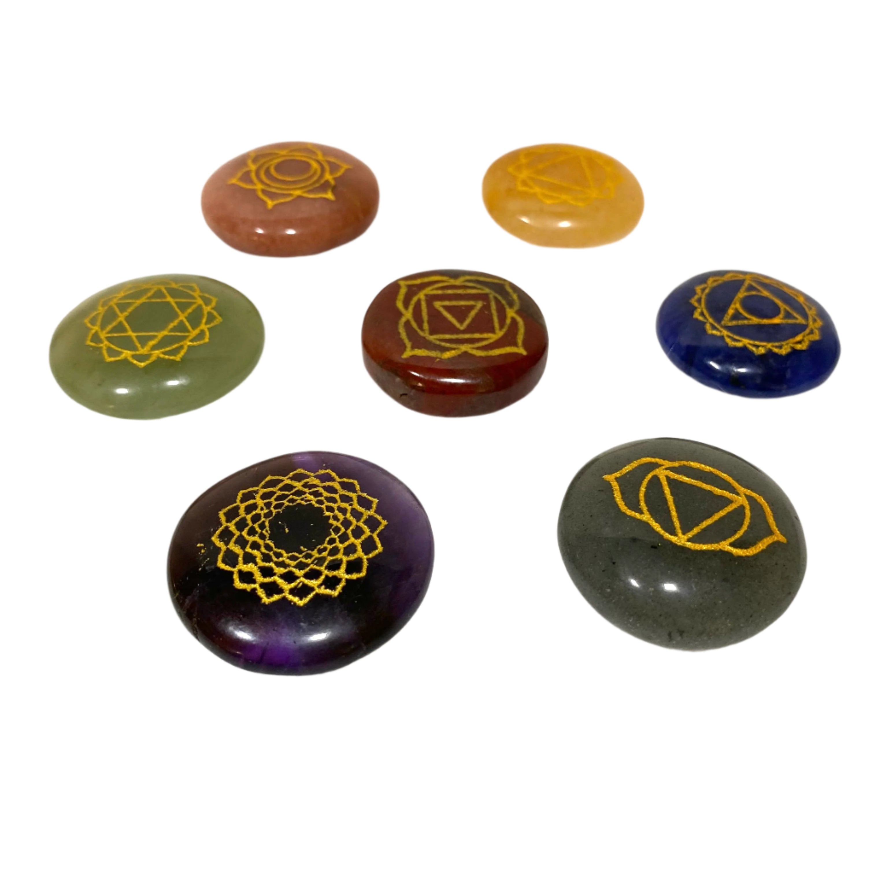 Set of seven chakra stones with gold symbols on a white background