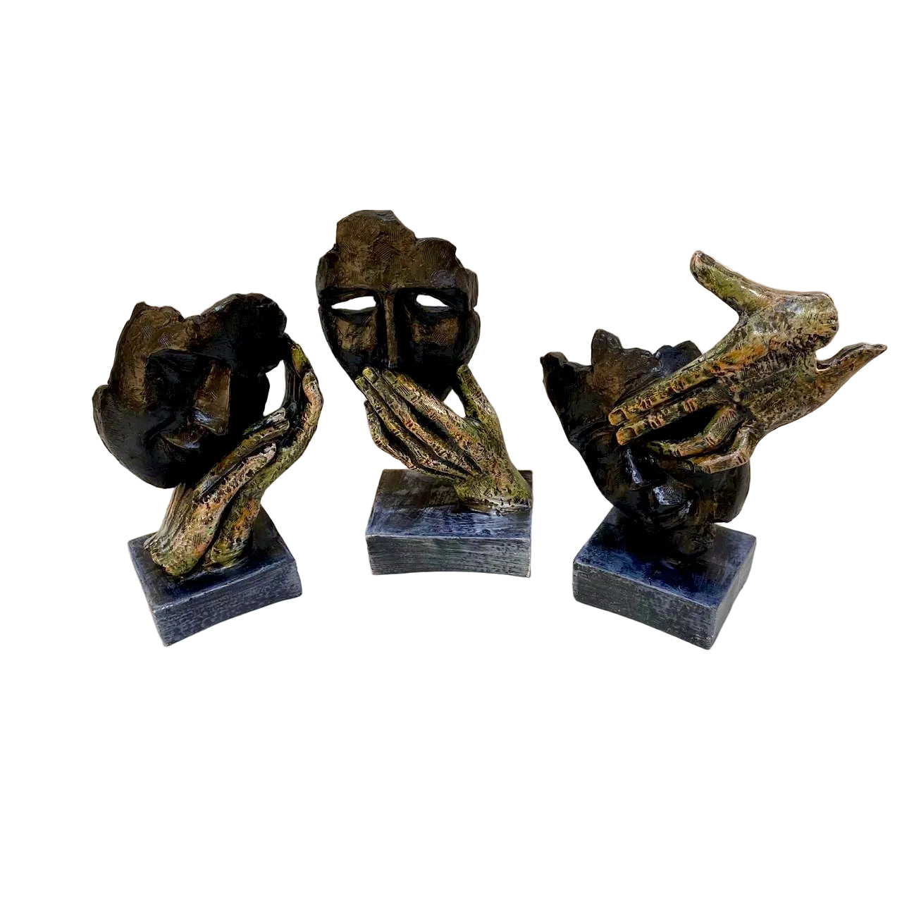 Three abstract sculptures on a white surface with a light-colored wall background