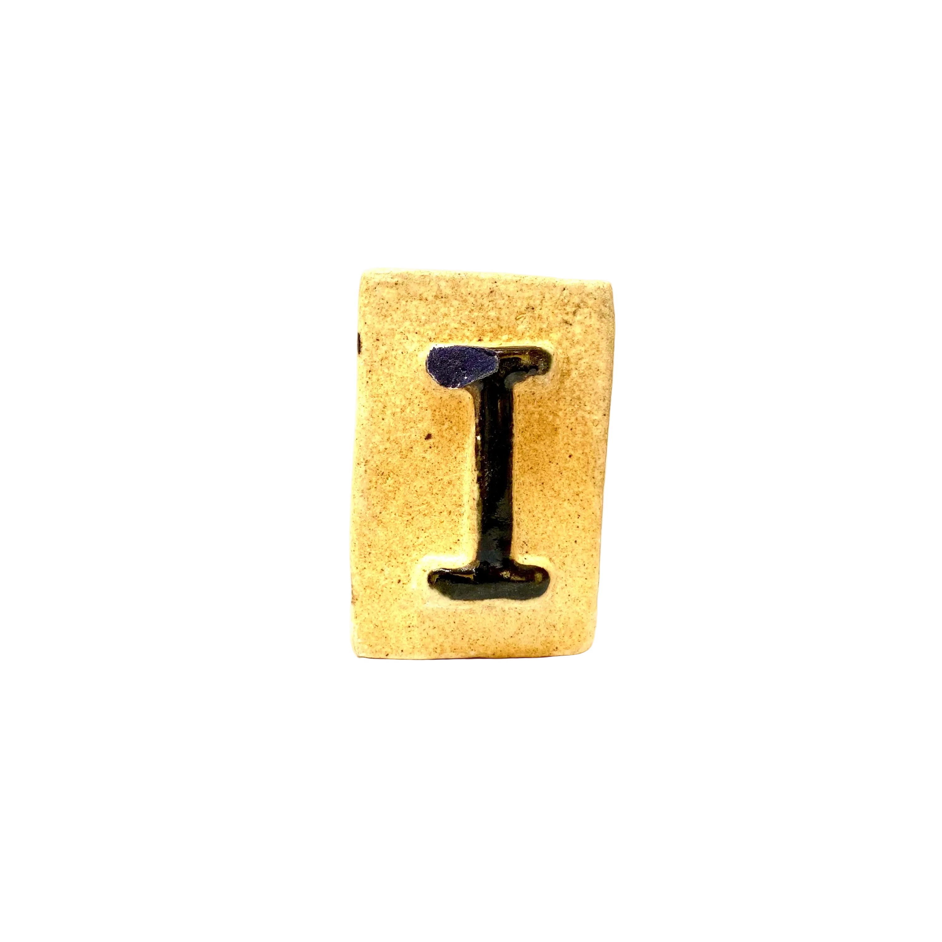 Letter 'I' on a wooden block with a white background