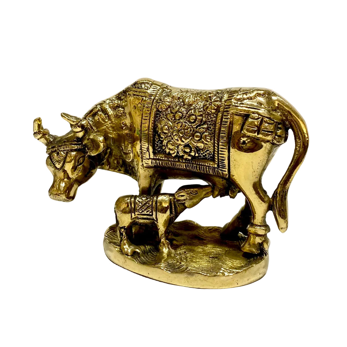 A decorative brass cow and calf figurine with ornate engraved patterns, displayed on a light-colored surface against a plain white background.