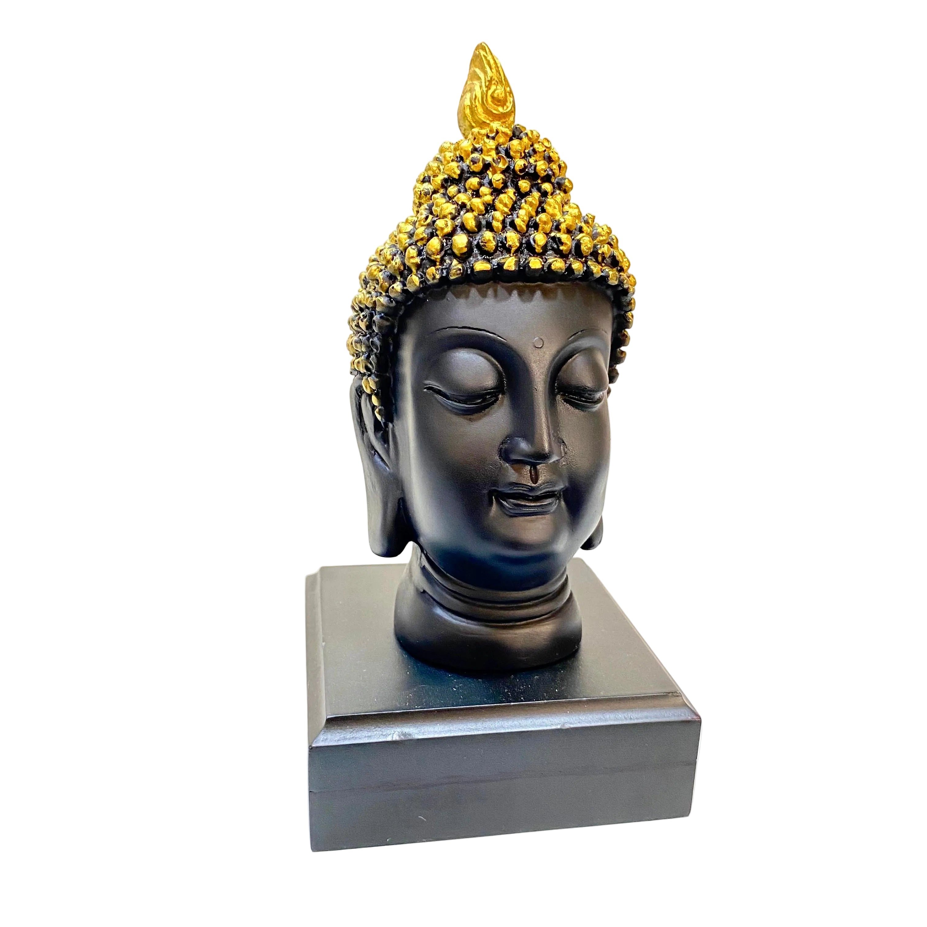 Buddha head sculpture with gold hairpiece on a white surface