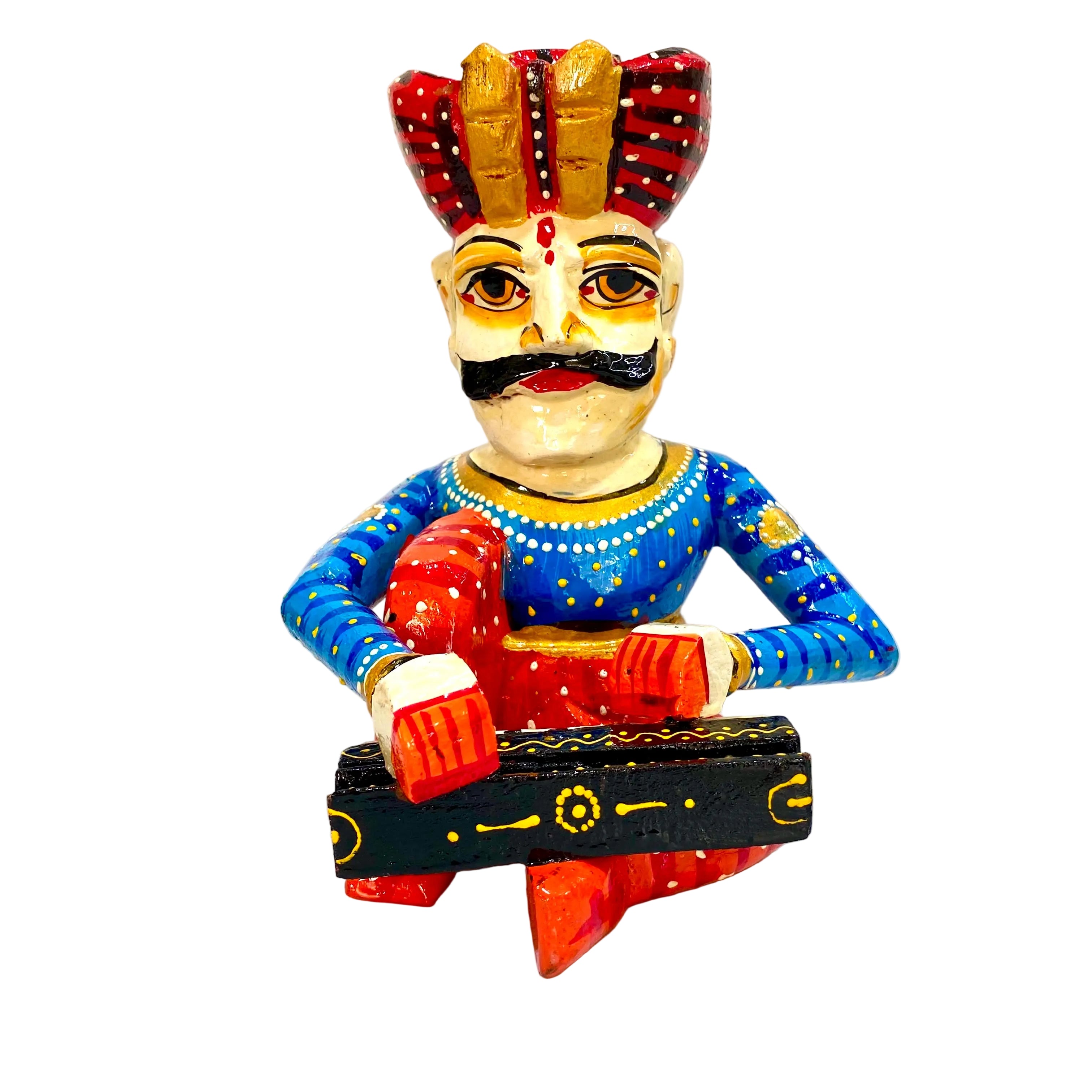 Hand-painted folk art figurine of a musician playing a black and red sitar, featuring a beige face with a black mustache, a blue patterned tunic, and a red and gold headdress, set against a plain white background.