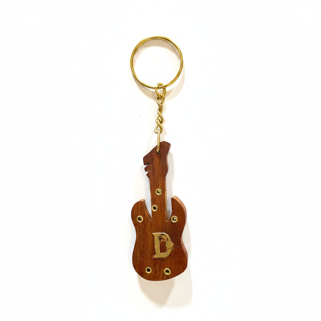 Wooden guitar-shaped keychain with a letter 'D' on a white surface.