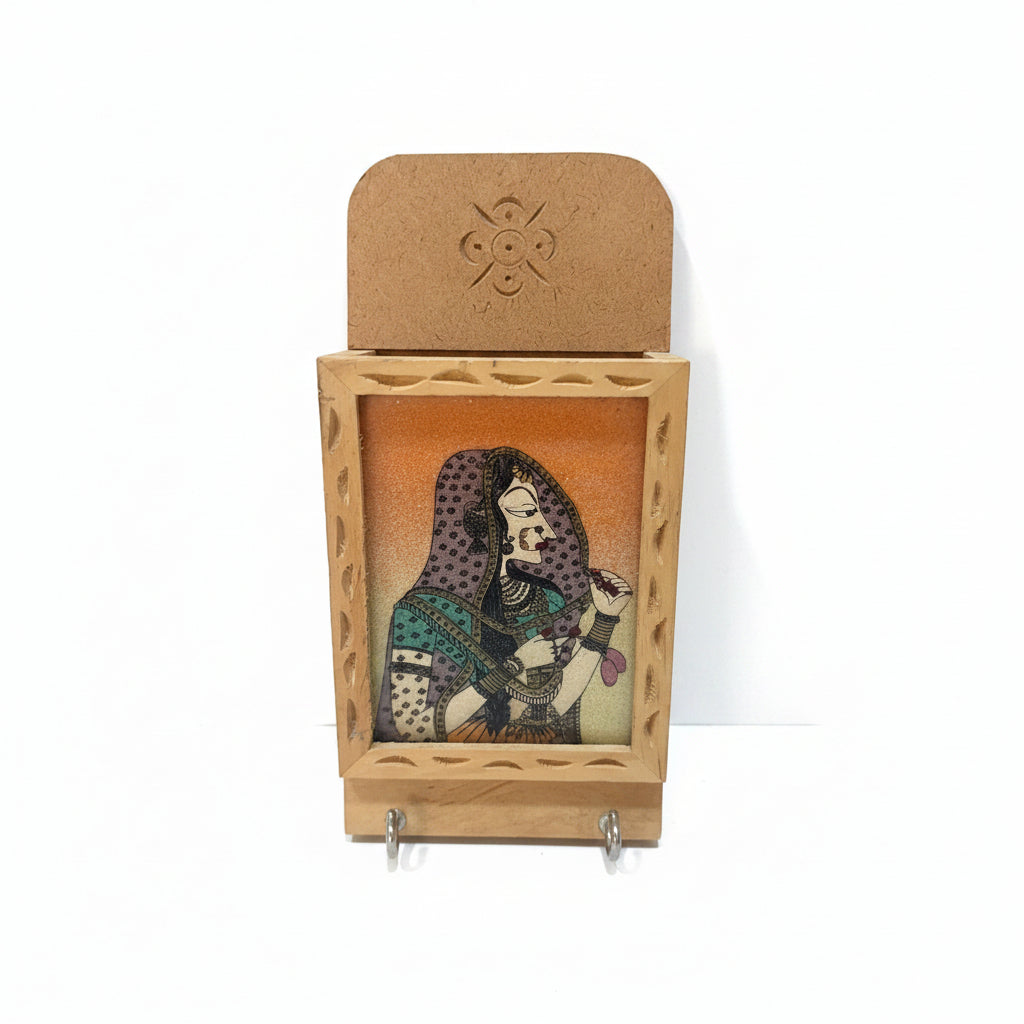 Wooden key holder with a decorative figure on a white surface