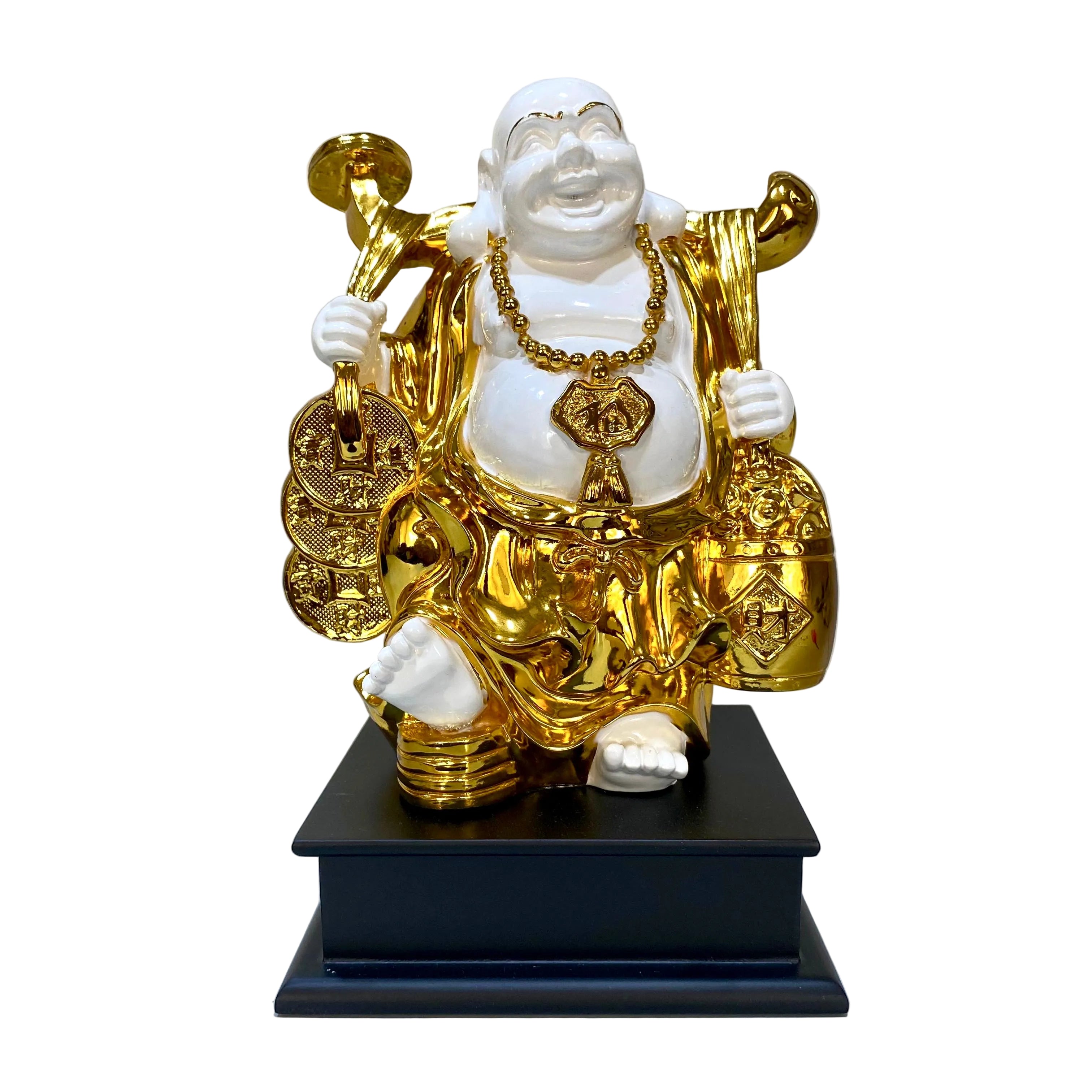 Gold and white Buddha statue on a black base against a light gray wall.