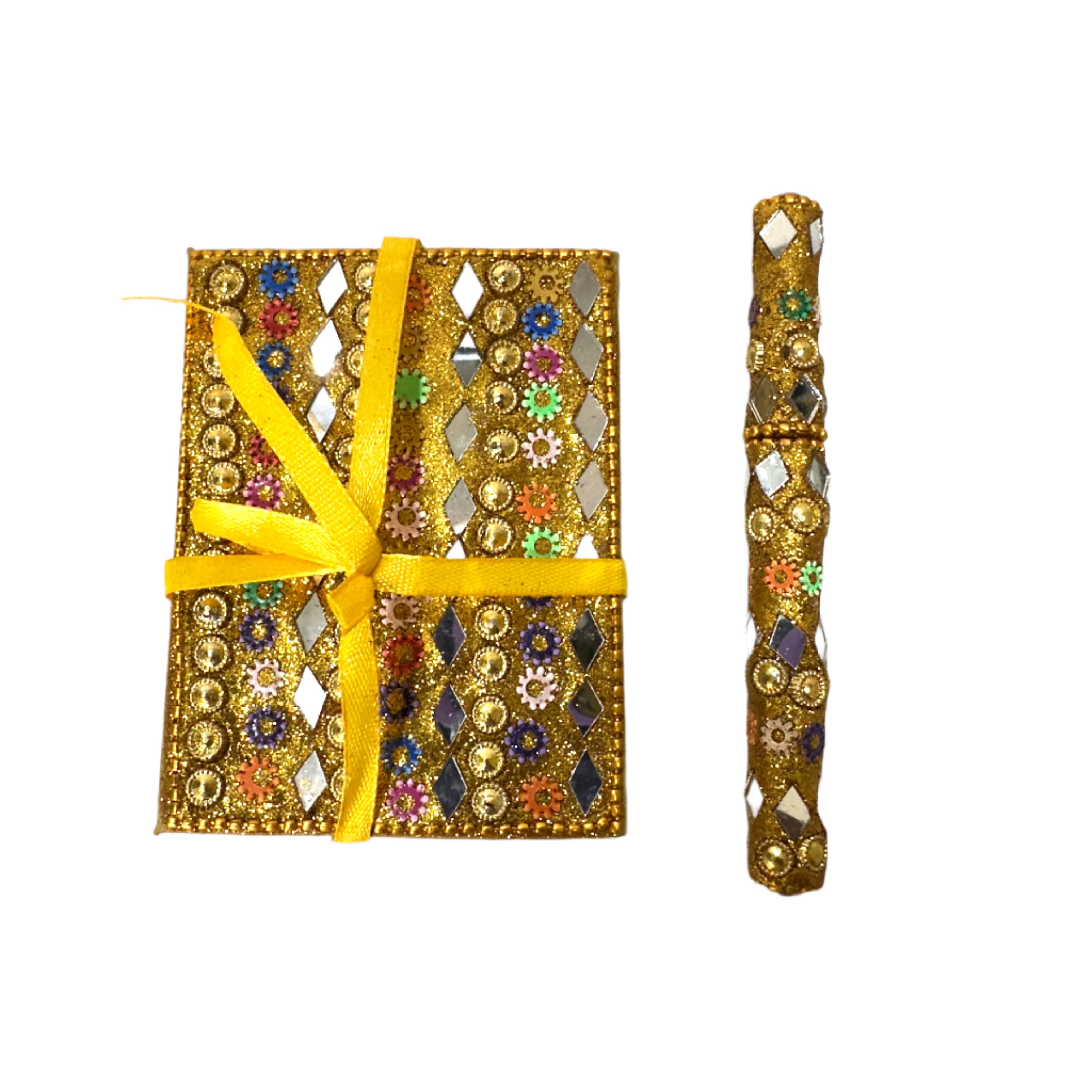 Decorative box with a yellow ribbon and ornate gold and gemstone design on a white surface.