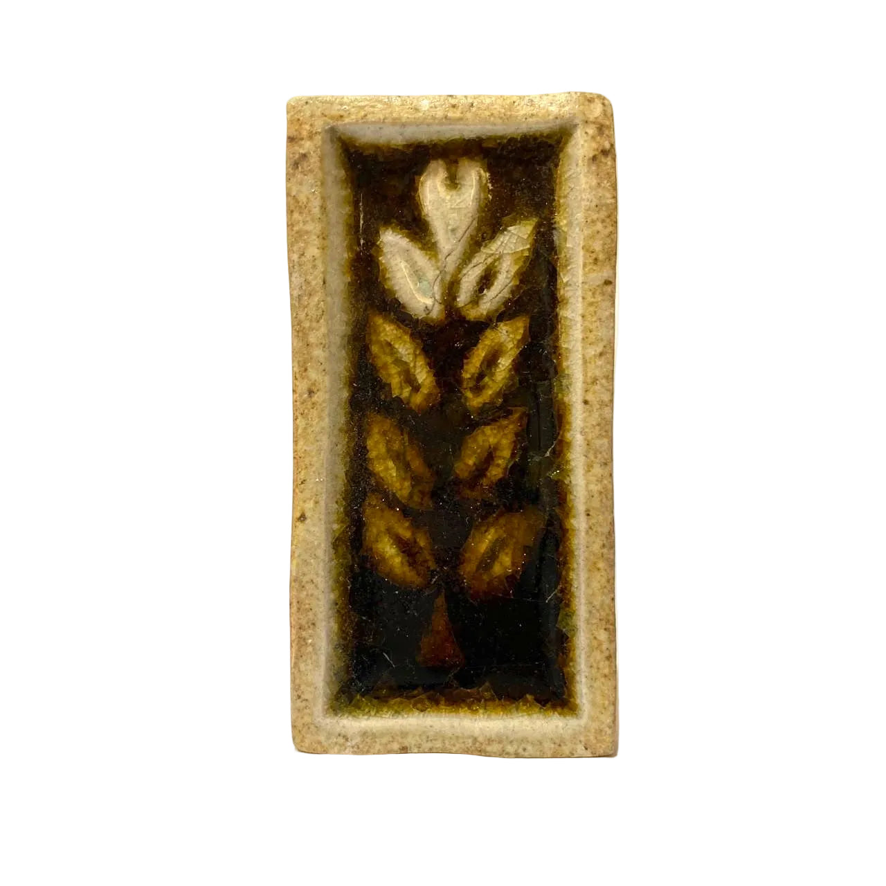 Rectangular ceramic tile with leaf design on a white background