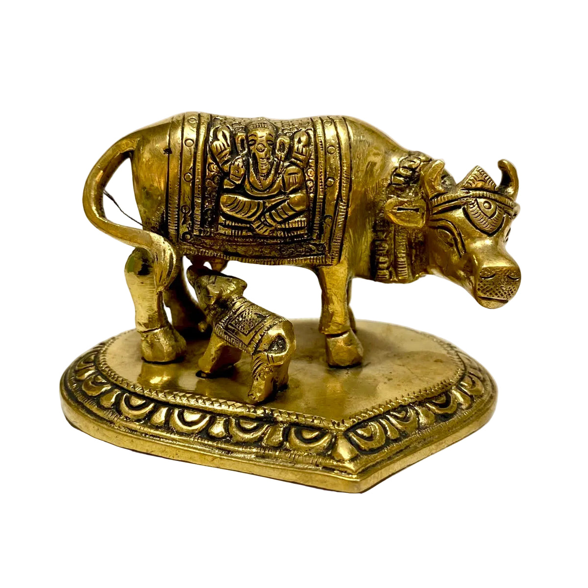 A brass cow and calf figurine with detailed carvings, standing on an ornate decorative base against a plain white background.