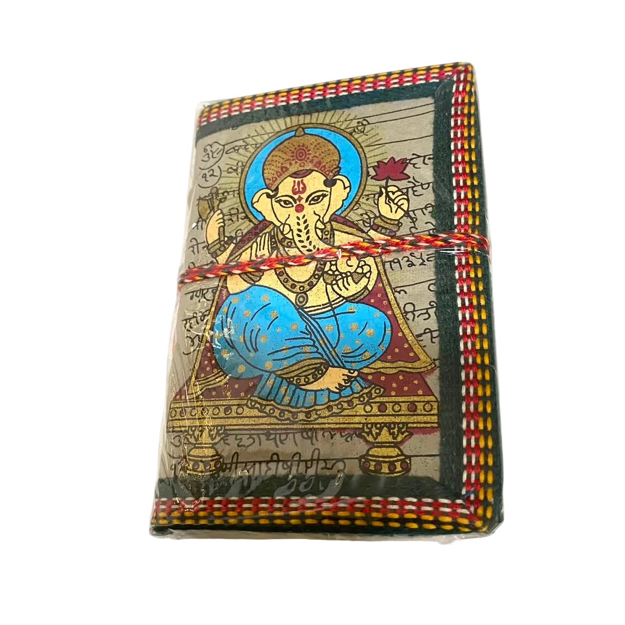 A small rectangular notebook or journal wrapped in clear plastic, featuring a hand-painted illustration of Ganesha on the cover with Devanagari script and red, yellow, and black striped binding.