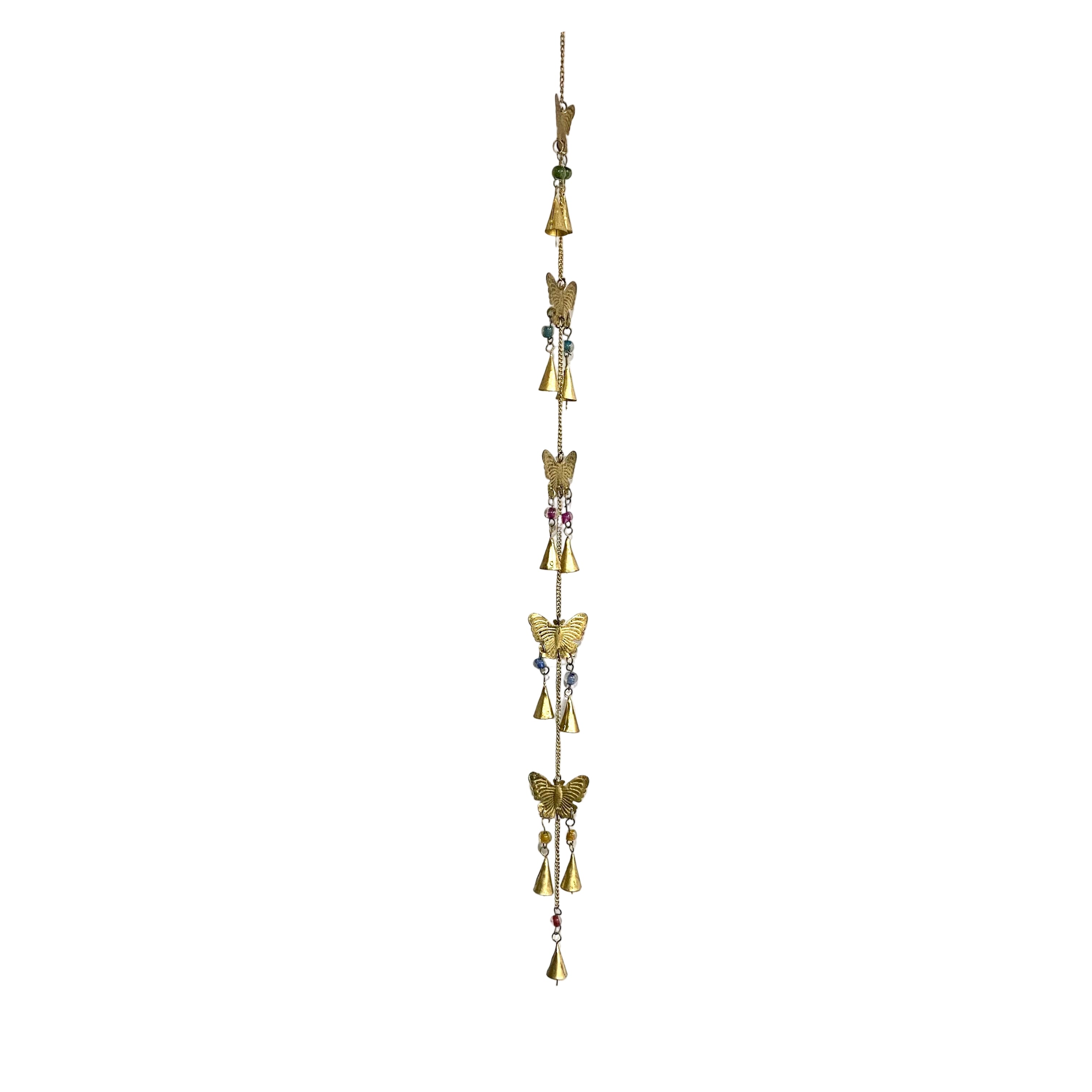 Decorative hanging with gold bells and butterfly shapes on a white wall.