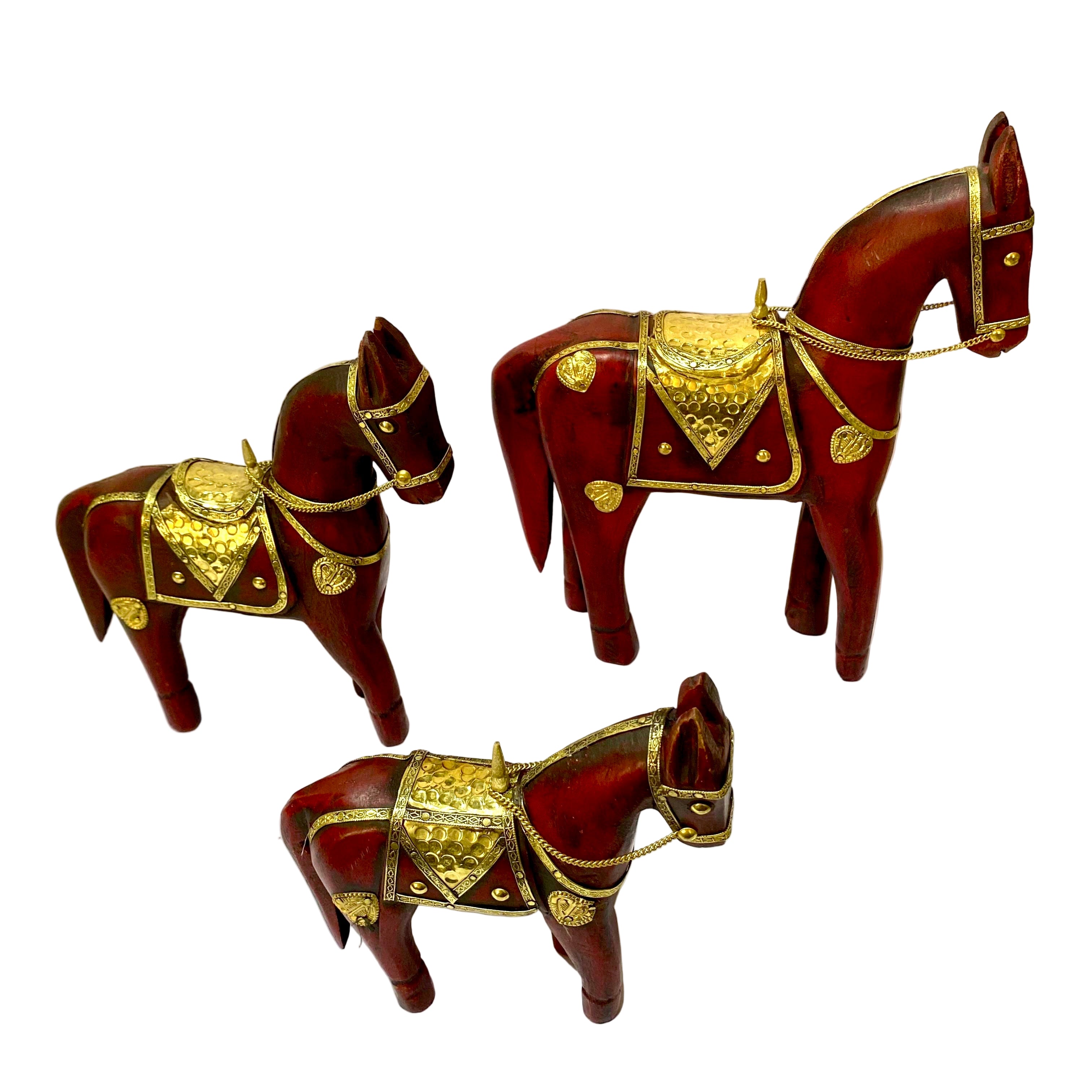 Three decorative horse figurines with gold accents on a white surface.