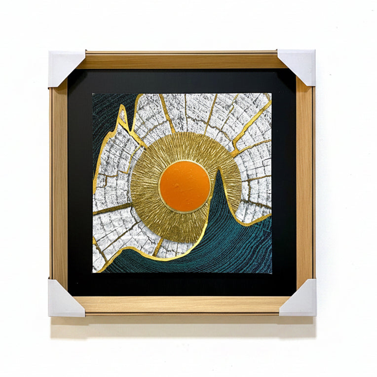 Framed artwork with a gold and orange circular design on a textured wall background