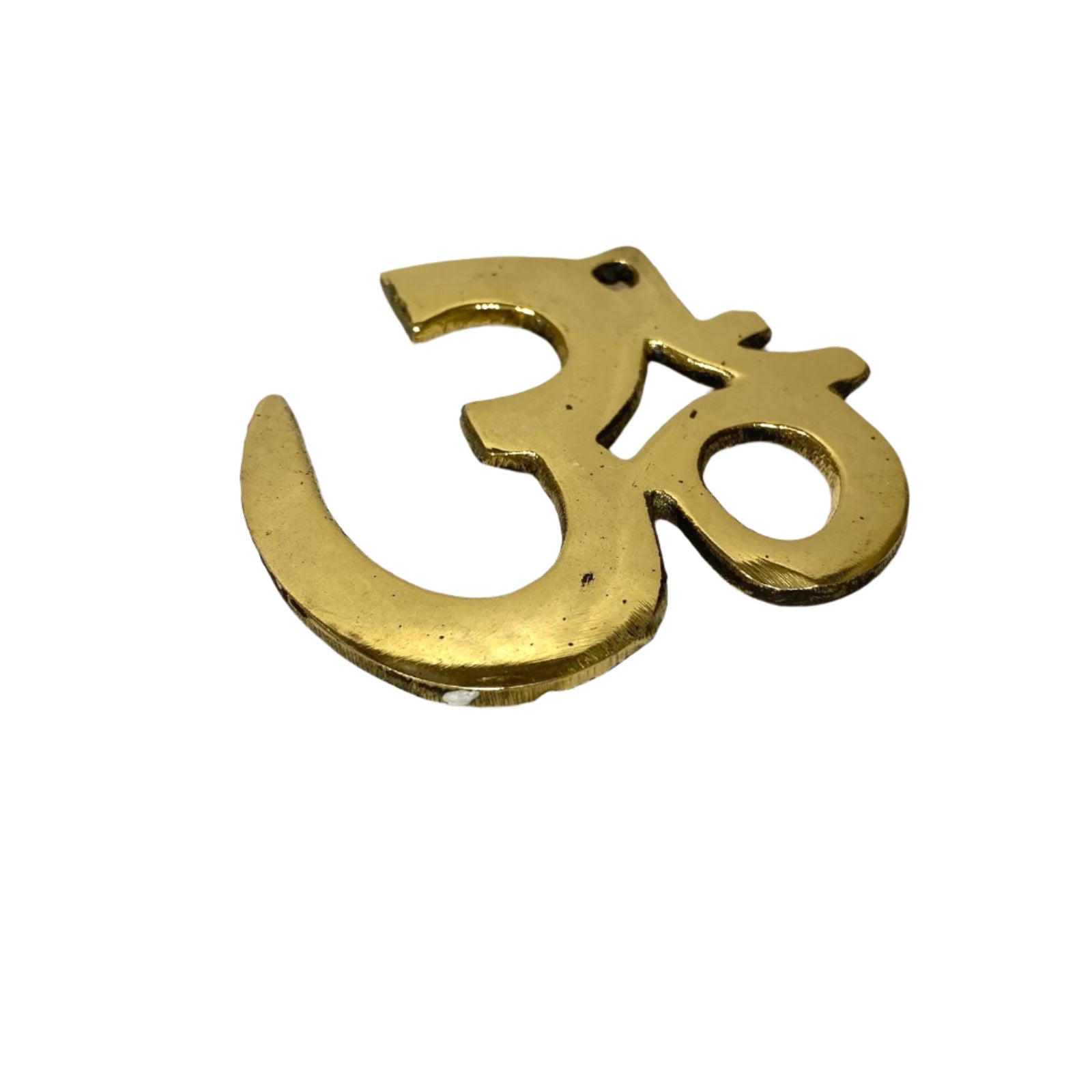 Brass Om symbol pendant on a textured white background