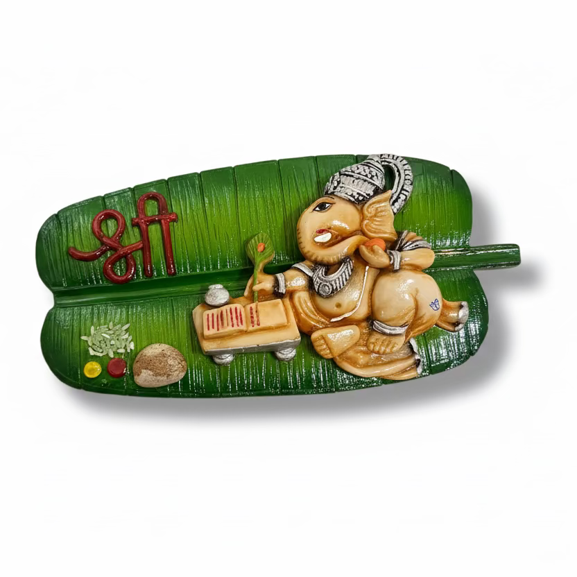 Decorative wall hanging with a figurine of a child playing a flute on a green leaf-shaped base.