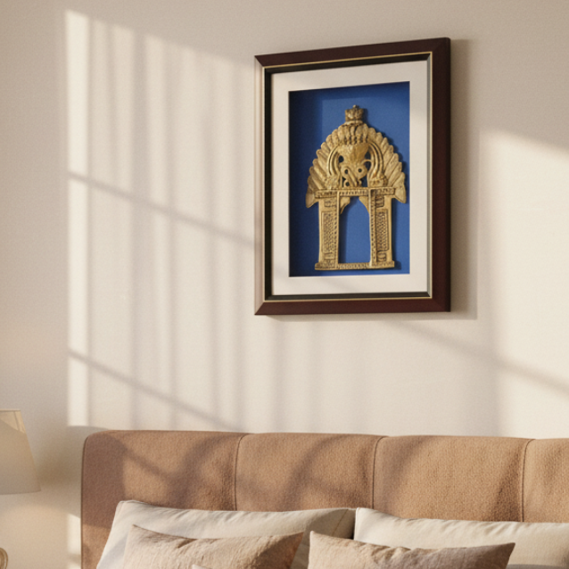 A framed decorative wall art piece featuring a metallic gold arch-shaped ornament mounted on a vivid blue backing, set within a white mat and a dark reddish-brown wooden frame.