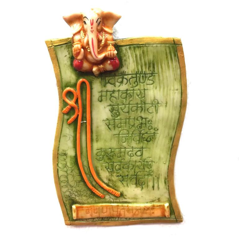 Decorative wall plaque with Ganesha figure and engraved text on a white background