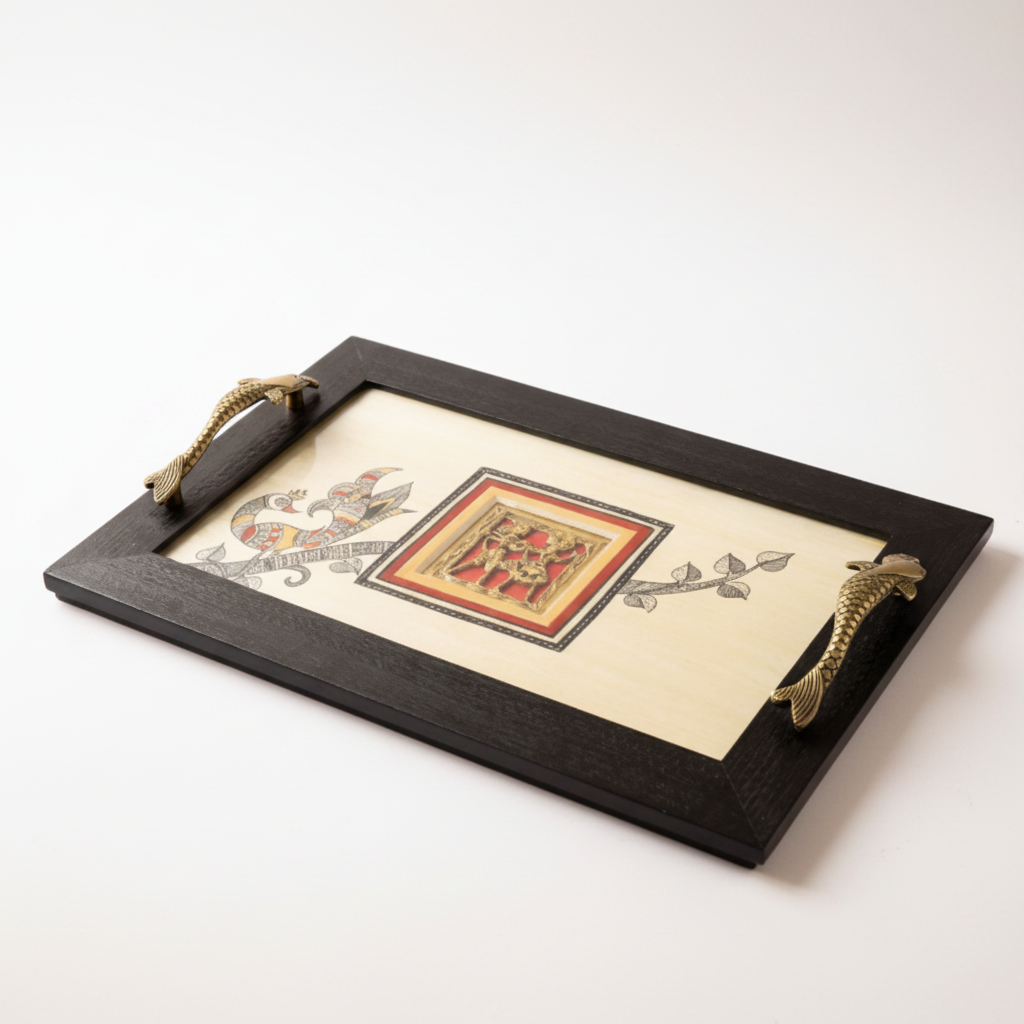 A rectangular serving tray with a dark wood frame and ornate brass handles, featuring a cream-colored center with a central red and gold illustration and floral motifs, resting on a woven jute mat near a window and green plant.