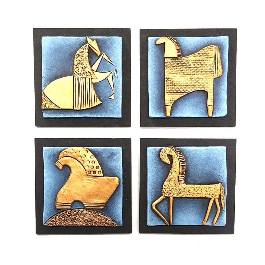 Four decorative wall art pieces with gold animal figures on a blue background