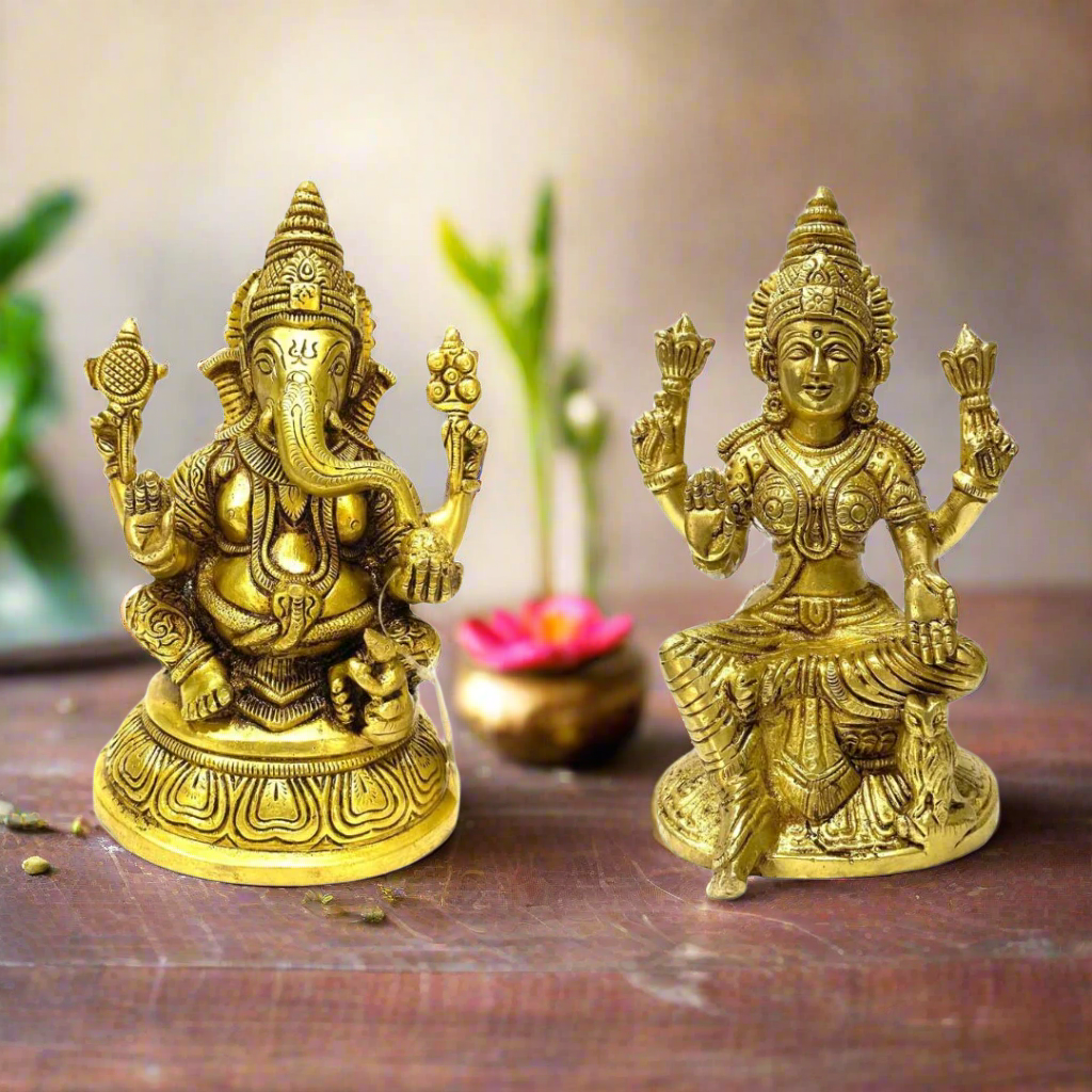 Two gold-colored statues of Hindu deities on a white background