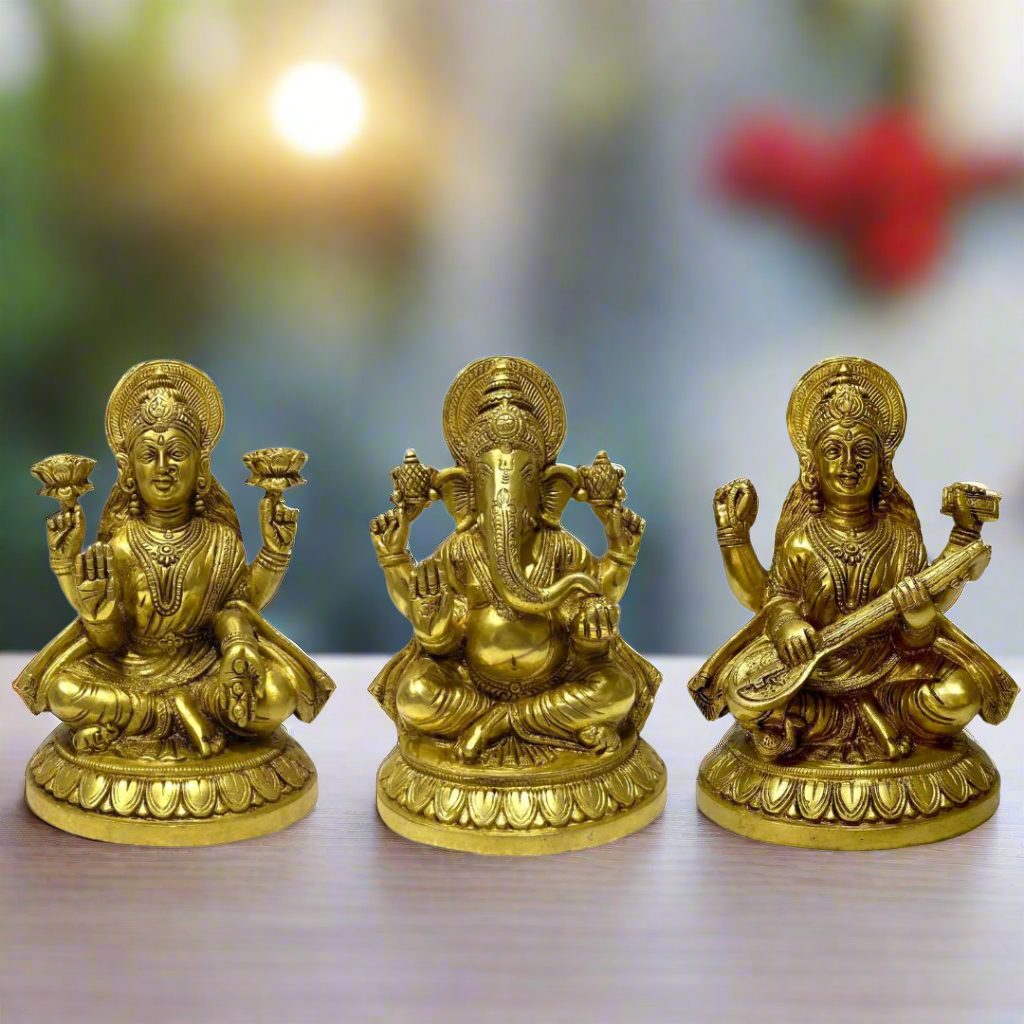 Three gold-colored statues of Hindu deities on a white background